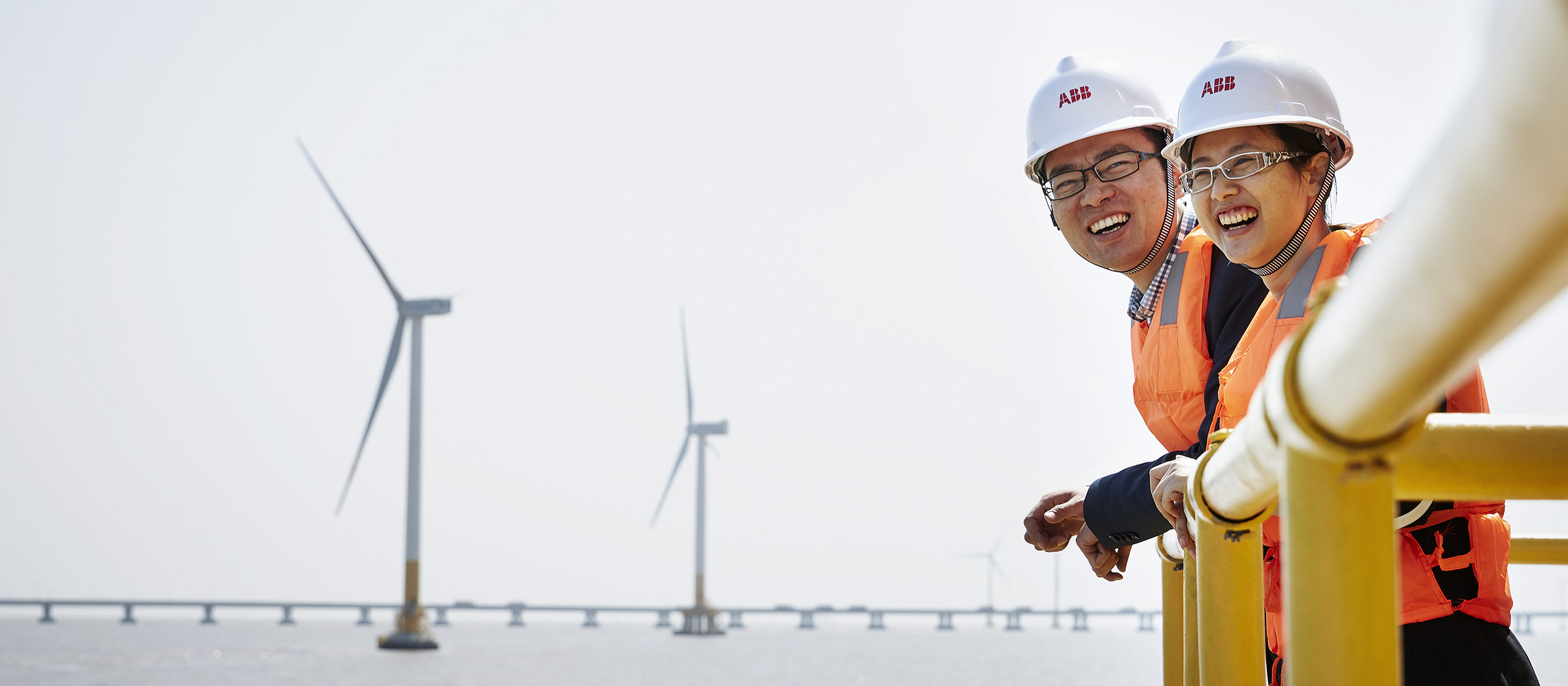 ABB engineers with offshore wind park in background (photo)