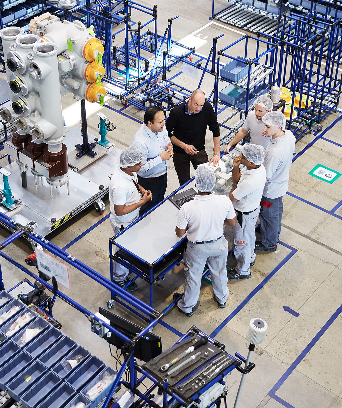 ABB employees standing in a production plant and discussing (photo)